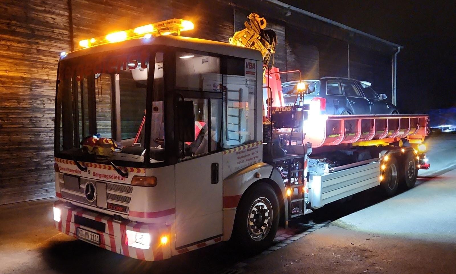 Mercedes Econic Bergungsfahrzeug bei Nachteinsatz mit Warnbeleuchtung