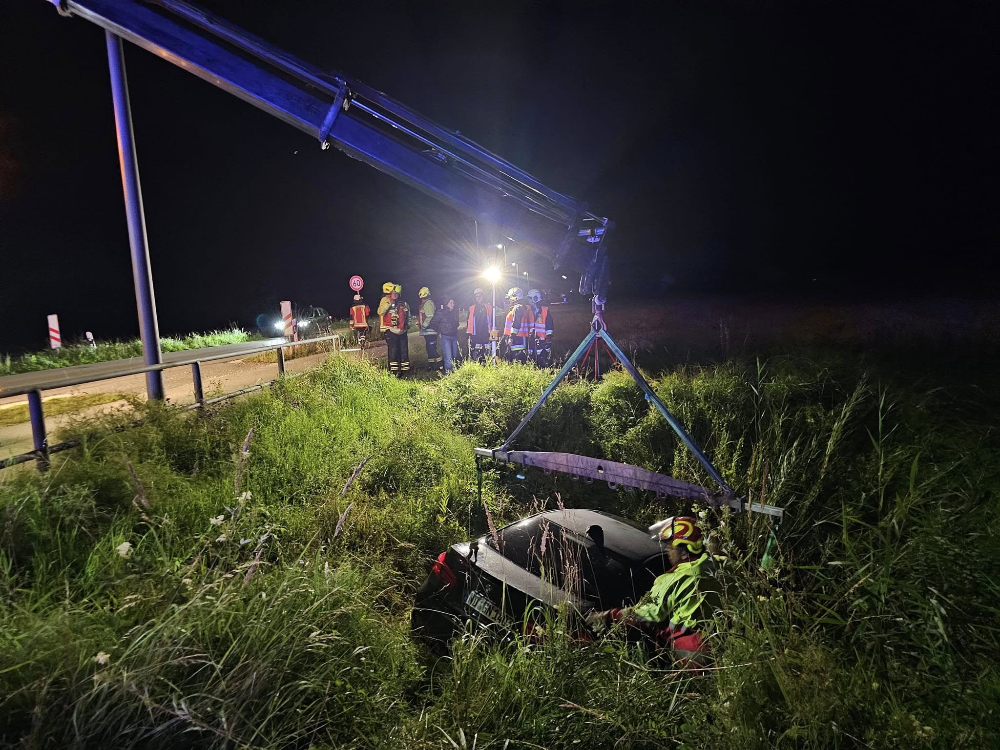 Nachtbergung — Kran hebt Unfallwagen aus dem Graben, Feuerwehr und Bergedienst im Einsatz