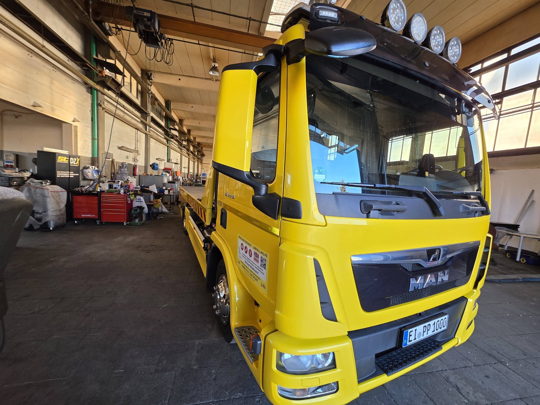 Bergedienst Widdmann bei Sonnenuntergang — Abschleppfahrzeug lädt Unfallwagen auf